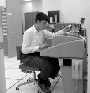 Andrew Behrens '71 sprawdza dane wyjściowe z jego Teletype model 35. W tle widać karty perforowane IBM. (Zdjęcie Adriana N. Boucharda/udostępnione przez Rauner Special Collections Library)